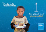 Virtual charity Christmas gift card design featuring smiling young boy holding a plate of food against a blue starry background with text reading 'Feed a child this Christmas' and 'This gift will feed a hungry child.' A Mary's Meals logo appears in the lower right. Virtual gift card design.