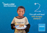 Virtual charity Christmas gift card design featuring smiling young boy holding a plate of food against a blue starry background with text reading 'Feed a child this Christmas' and 'This gift will feed two hungry children.' A Mary's Meals logo appears in the lower right.