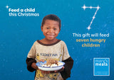 Virtual charity Christmas gift card design featuring smiling young boy holding a plate of food against a blue starry background with text reading 'Feed a child this Christmas'. A Mary's Meals logo appears in the lower right.